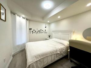 a bedroom with a white bed and a window at Comfortable 2BR Getaway with Extra Lounge Space in Toronto