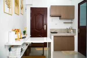 a kitchen with a white counter and a brown door at Casa Marelle in Lapu Lapu City