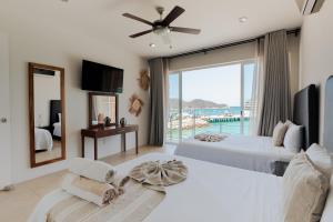 a bedroom with two beds and a view of the ocean at Suites La Playa in Santa Cruz Huatulco