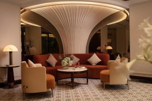 a lobby with a couch and chairs and a table at Luxeden Signature hotel in Hanoi +33 photos
