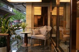 a patio with a chair and a table and a window at Luxeden Signature hotel in Hanoi