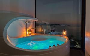 a bath tub in a room with a window at Geoje Marepos Pension in Geoje +9 photos