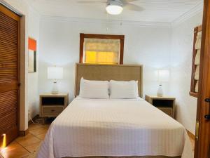 a bedroom with a large bed with two night stands at Serenity Sands Cayman in Bodden Town +23 photos