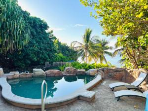 a swimming pool with a slide in a resort at Serenity Sands Cayman in Bodden Town
