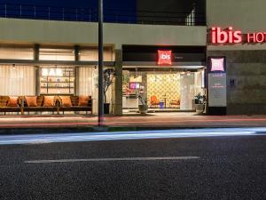 a store front with benches in front of a building at Hotel ibis Bragança in Bragança +67 photos