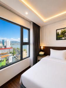 a hotel room with a bed and a large window at Hon Chong Retreat Hotel Nha Trang in Nha Trang