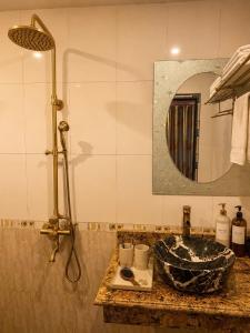 a bathroom sink with a shower and a mirror at Việt Anh Hotel in Sapa
