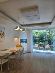 a dining room with a table and chairs and a large window at South Sagye Jeju in T'ogi-dong