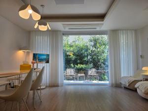 a living room with a dining table and a large window at South Sagye Jeju in T'ogi-dong