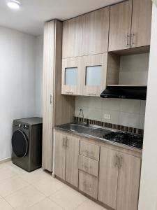 eine Küche mit Holzschränken und einer Waschmaschine und einem Trockner in der Unterkunft entresierras in Valledupar