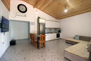 a kitchen with a table and a clock on the wall at Lakeview Villa Nardi in Ksamil