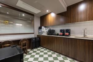 a kitchen with wooden cabinets and a checkered floor at Onjae Stay Seongsu in Seoul