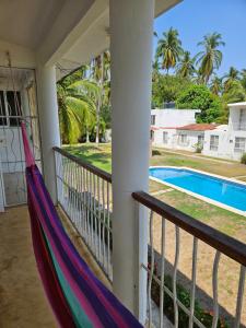 a porch with a hammock and a swimming pool at Alojamiento El Dorado in Barrio Nuevo