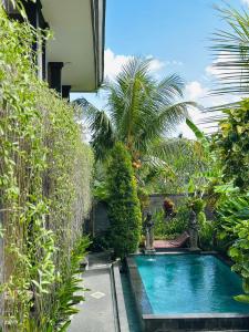 a swimming pool in the middle of a garden at Pulu Sari Suite Ubud in Ubud