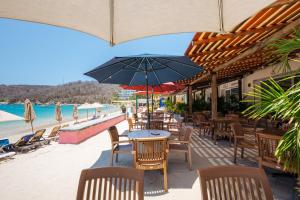 a restaurant with tables and chairs on the beach at Suites La Playa in Santa Cruz Huatulco
