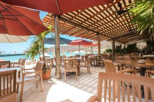 an outdoor restaurant with tables and chairs and umbrellas at Suites La Playa in Santa Cruz Huatulco