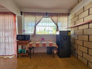 a kitchen with a table and a refrigerator and a window at Alojamiento El Dorado in Barrio Nuevo