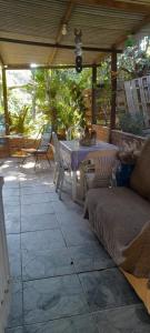a patio with a table and chairs and a couch at Abrigo e Camping Recanto das Arvores in Itamonte