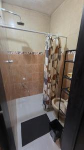 a bathroom with a shower curtain and a toilet at Hogar ideal in Orizaba