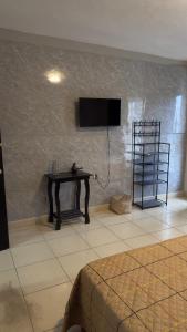 a room with a table and a tv on a wall at Hogar ideal in Orizaba