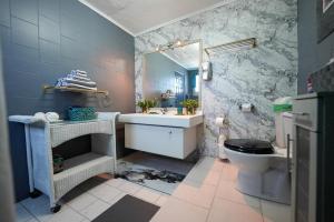 a bathroom with a sink and a toilet and a mirror at Rowy's appartement in Willemstad +16 photos