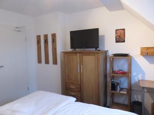 a bedroom with a bed and a flat screen tv at Bredeneeker Gasthaus in Rastorf