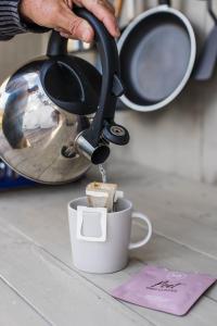 a person is pouring coffee into a coffee cup at Captain Moonlite Bubbletent at Mirumiru in Tenterfield