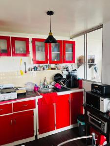 a kitchen with red cabinets and a sink at Lagom 406 Habitación en depa duplex in Mexico City