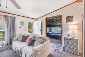 a living room with a couch and a bedroom at One Peace Cottage in Deep Hole
