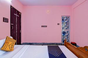 a bedroom with a bed and a pink wall at Hotel Shivam palace in Lalitpur