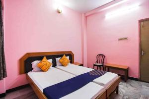 a bedroom with a bed with orange and blue pillows at Hotel Shivam palace in Lalitpur