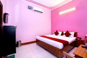 a bedroom with a large bed with pink walls at Hotel Shivam palace in Lalitpur