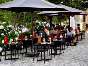 a group of people sitting at tables under umbrellas at Mercure Nantes Centre Gare in Nantes