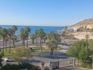 a parking lot with palm trees and the ocean at Ibis Budget Alicante in Alicante