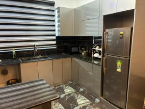 a kitchen with a stainless steel refrigerator and a sink at JK Residence Trincomalee in Trincomalee
