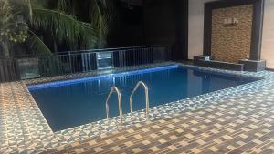 a swimming pool with two metal bars in it at JK Residence Trincomalee in Trincomalee