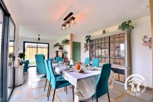 a dining room with a table and blue chairs at Entre terre et mer in Cherrueix