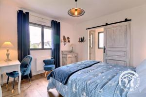 a bedroom with a bed and a desk and a table at Entre terre et mer in Cherrueix