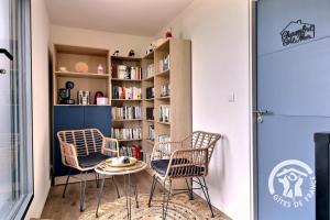 a room with three chairs and a book shelf at Entre terre et mer in Cherrueix