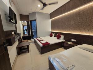 a hotel room with two beds and a mirror at Hotel Vrindavan in Fatehpur Sīkri