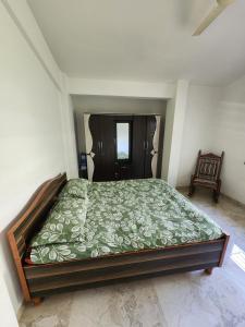 a bedroom with a bed with a green comforter at Castel Rock in Nashik