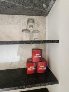 a shelf with glasses and books on it at Castel Rock in Nashik