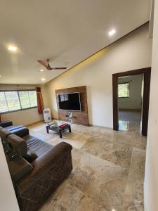 a living room with a couch and a flat screen tv at Castel Rock in Nashik