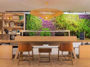 a restaurant with a large wall of flowers at ibis Dubai World Trade Centre in Dubai