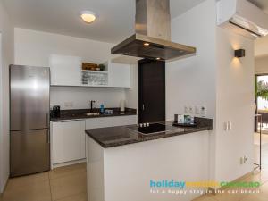 a kitchen with a refrigerator and a counter top at Apartment 387 Blue Bay in Dorp Sint Michiel +5 photos