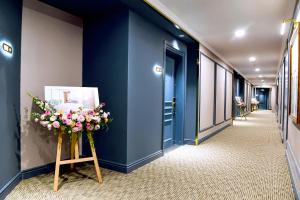 a corridor with blue walls and flowers in a hallway at Centara Hotel & Residences Van Don in Cái Rồng