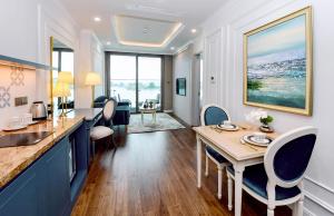 a kitchen and dining room with a table and chairs at Centara Hotel & Residences Van Don in Cái Rồng