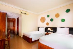 a hotel room with two beds and a desk at Apsor Villa in Phumĭ Réach Born (2)