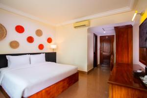 a bedroom with a large white bed in a room at Apsor Villa in Phumĭ Réach Born (2)
