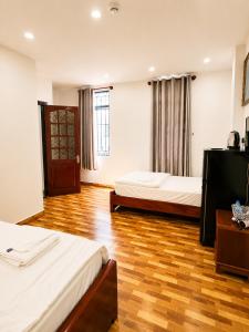 a hotel room with two beds and a television at Khách sạn Phương Danh in Phú Tài (1)